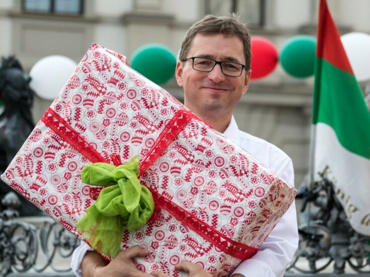Foto von Michael Bitzer mit einem großen Geschenk in der Hand